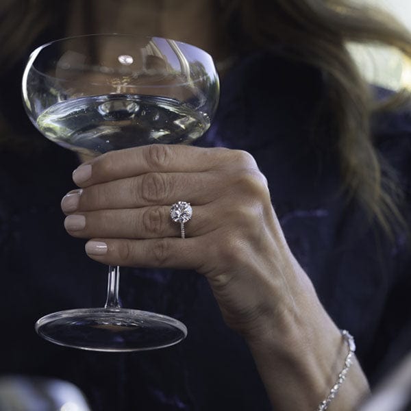 Woman holding champagne glass with diamond ring