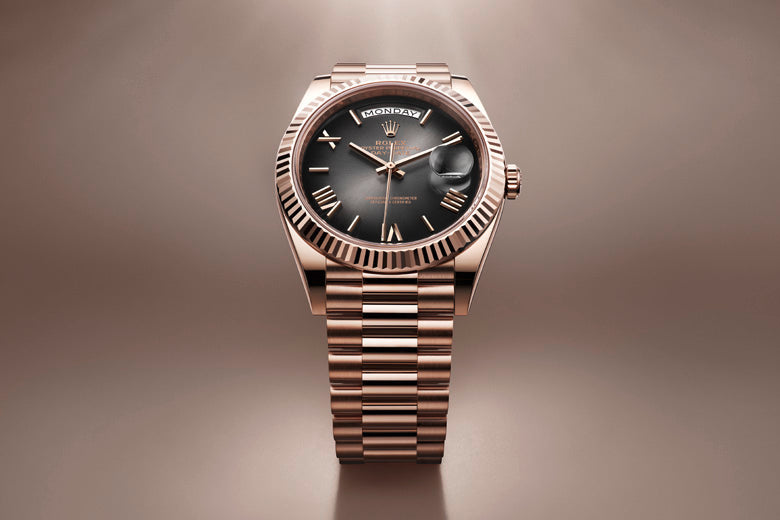 A luxurious wristwatch with a gold-toned metal band and a black dial. The watch has a fluted bezel, hour markers, and hands in matching gold tones. The background is a gradient of soft brown hues, highlighting the watch as the focal point.